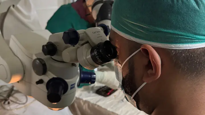 A surgeon operating with an ophthalmic microscope